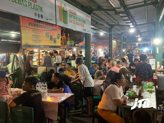 Vibrant evening scene at Sindhu Night Market in Sanur, Bali, with visitors enjoying local dishes at lively food stalls