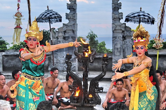 A Balinese dancer gracefully performs the captivating Kecak Dance on the open stage of Uluwatu Temple, creating a mesmerizing harmony of sound and movement