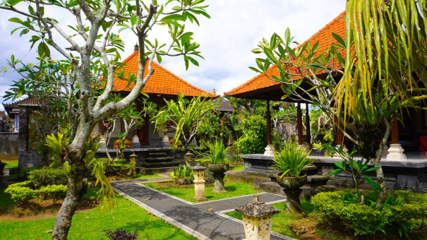 Traditional Balinese house surrounded by lush tropical gardens, showcasing the rural charm and authentic architecture of Bali.