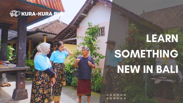 Visitors learning about Balinese culture from a local elder in a traditional Balinese compound, part of Kura-Kura Bus's educational and cultural trip in Bali.