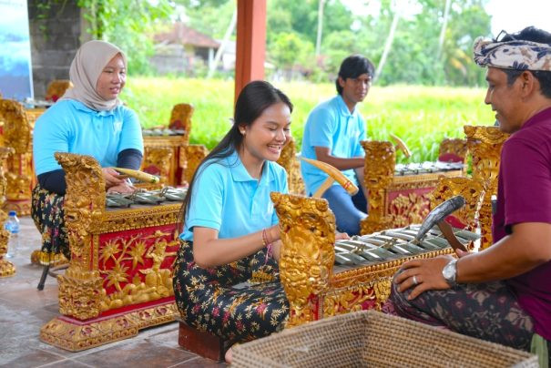Tourists learning Balinese gamelan music during a cultural lesson in Bali