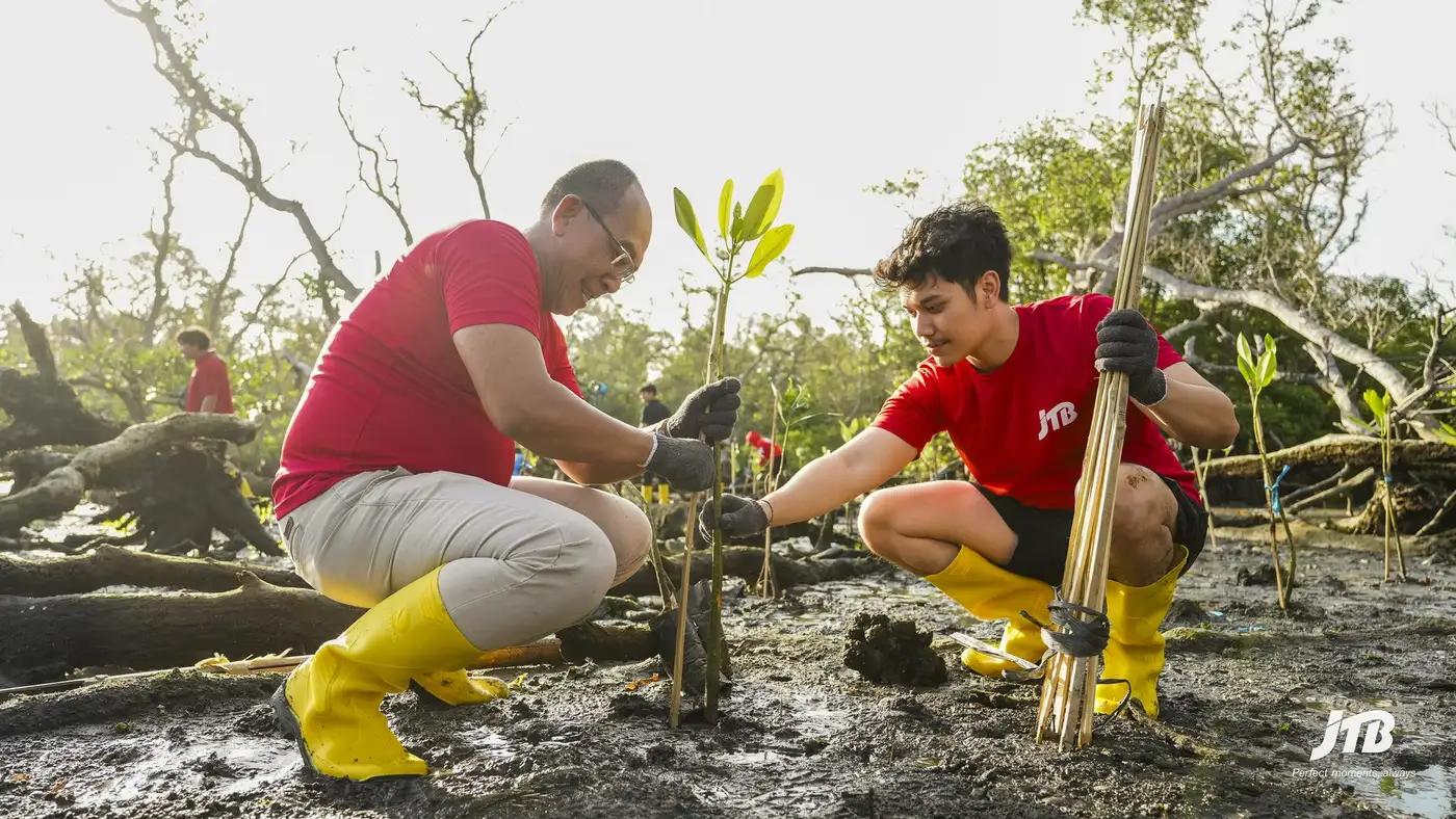 Students and partners participating in mangrove planting with JTB Indonesia