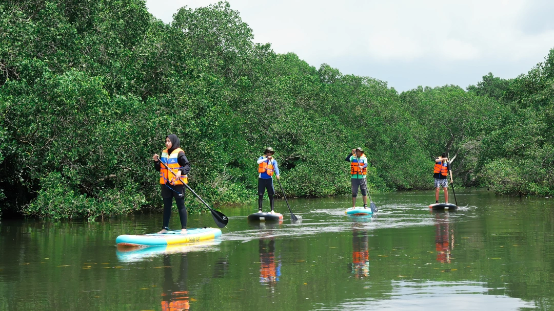 Guests paddling through Bali mangrove forest during beginner SUP tour