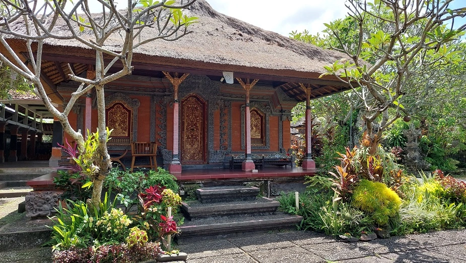 Traditional Balinese house surrounded by tropical plants in rural Bali