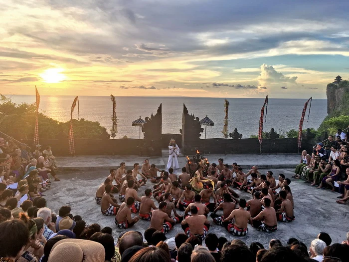 Kecak Dance performance at Uluwatu Temple during sunset, with dancers seated in a circle and the ocean as a stunning backdrop